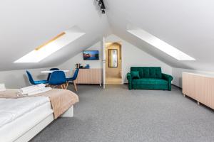 a bedroom with a bed and a green chair at Kashubian Resort in Władysławowo