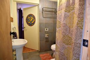 y baño con lavabo, aseo y ducha. en Hostal Ayni en San Pedro de Atacama