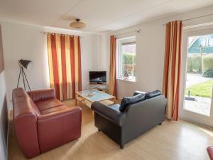 uma sala de estar com um sofá e uma cadeira em Holiday home near Grevelingen Lake em Zonnemaire