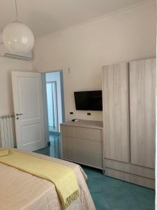 1 dormitorio con 1 cama y TV de pantalla plana en Casa Ausilia Trilocale, en Amalfi