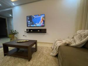a living room with a couch and a tv on the wall at Résidence du parc in Mohammedia