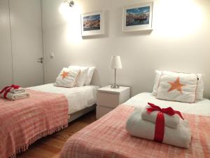 ポルトにあるLusitania Garden Apartment - Jardim Privadoのベッドルーム1室(赤い弓を用いたベッド2台付)