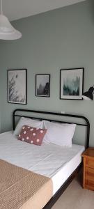 un letto in una camera da letto con tre immagini sul muro di Dassia Green Apartments a Dassia
