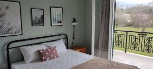 una camera con letto e vista su un balcone di Dassia Green Apartments a Dassia