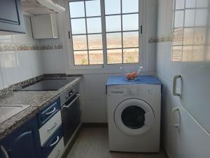 una cucina con lavatrice e finestra di Apartamento Soleado a Los Abrigos