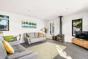 a living room with a couch and a fireplace at Relax on Snowberry - Wanaka Holiday Home in Wanaka