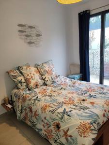 um quarto com uma cama com um edredão colorido em Ailleurs Land em Carry-le-Rouet