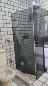 een badkamer met een toilet en een glazen douche bij Casa Aeroclube in João Pessoa