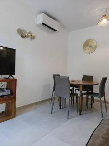 a dining room with a table and chairs and a tv at Ailleurs Land in Carry-le-Rouet