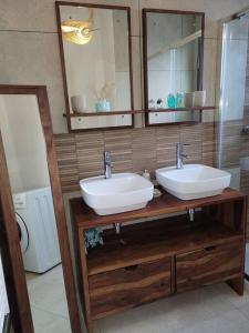 a bathroom with two sinks and a mirror at Ailleurs Land in Carry-le-Rouet