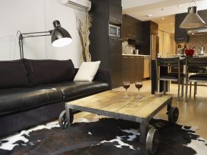 ein Wohnzimmer mit einem Sofa und einem Tisch mit Weingläsern in der Unterkunft Les Immeubles Charlevoix - Le 1168 in Québec