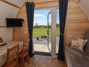 a room with a dining table and a sliding glass door at Husk in Harpham
