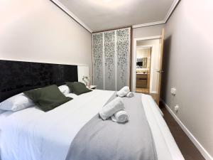 1 dormitorio con 1 cama blanca grande y toallas. en Villa Mercedes - 17001, en Santoña