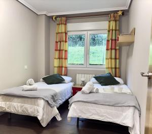 a bedroom with two beds and a window at Villa Mercedes - 17001 in Santoña