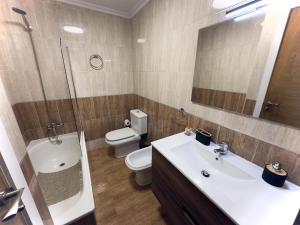 a bathroom with a sink and a toilet and a mirror at Villa Mercedes - 17001 in Santoña