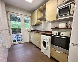 a kitchen with a washing machine and a washer at Villa Mercedes - 17001 in Santoña +5 photos