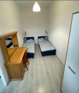een kamer met twee bedden en een tafel erin bij Apartament Kętrzyński in Kętrzyn