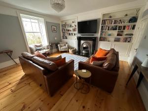 ein Wohnzimmer mit 2 Sofas und einem Kamin in der Unterkunft Laburnum Cottage in Alnwick