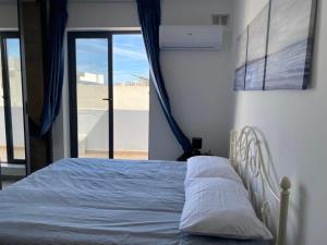 a bed in a bedroom with a view of the desert at Broadway By The Sea in St. Paul's Bay