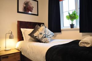 um quarto com uma cama com uma almofada e uma janela em The RedBridge House em Swindon