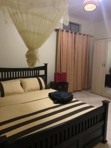 una camera da letto con un letto con una borsa sopra di Larry's Place - Gulu , Uganda a Gulu