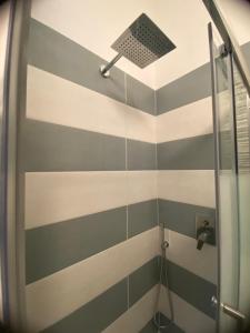 La salle de bains est pourvue d'une douche aux murs rayés. dans l'établissement Chiaro di luna, à Castellammare di Stabia