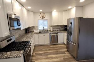 a kitchen with white cabinets and a stainless steel refrigerator at 75 Acre home with trails & outdoor fun tons of Wildlife in Saint Charles