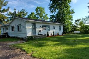 une petite maison blanche avec une cour d'herbe dans l'établissement 75 acres of trails & outdoor fun tons of Wildlife, à Saint Charles