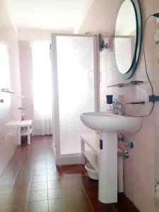 uma casa de banho com um lavatório branco e um espelho. em Relax, tramonti, natura e mare. Autentica Maremma em Gavorrano