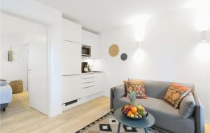 a living room with a couch and a bowl of fruit on a table at Nice Apartment In Lembruchdümmer See in Lembruch