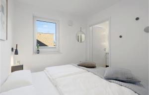 a white bedroom with two beds and a window at Nice Apartment In Lembruchdümmer See in Lembruch