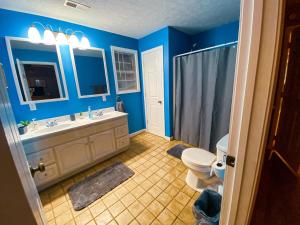 a blue bathroom with a toilet and a sink at 5 Star with Direct Access to Brimstone Recreation Game Room Comfortable Up to 4 Bedrooms Stylish in Huntsville