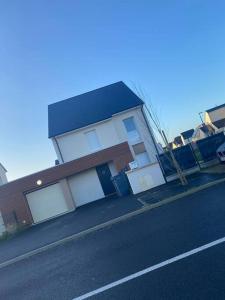 a house sitting on the side of a street at Belle maison neuve à 5 mn de la plage in Colleville-Montgomery