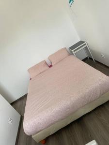 una pequeña cama rosa sentada en una habitación en Belle maison neuve à 5 mn de la plage, en Colleville-Montgomery