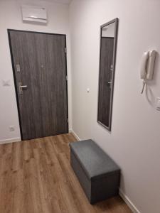 a room with a door and a stool and a mirror at Apartament Anna in Leszno