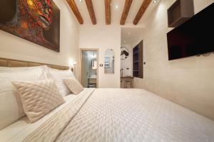 um quarto com uma cama branca e uma televisão de ecrã plano em Villa Urbi et Orbi 2 em Split