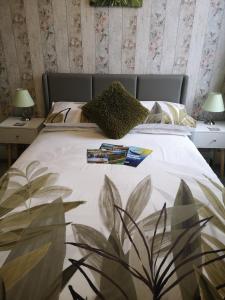 um quarto com uma grande cama branca e duas mesas em The Phoenix Guest House em Scarborough