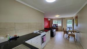a kitchen with a stove and a table in it at Stroll to the City Center in Minutes in Toowoomba