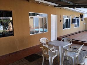 una mesa y sillas en el porche de una casa en Casa com piscina próximo à Avenida das Cataratas en Foz do Iguaçu