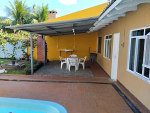 un patio de una casa con mesa y sillas en Casa com piscina próximo à Avenida das Cataratas en Foz do Iguaçu