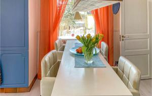 una mesa de comedor con un jarrón de flores. en 3 Bedroom Nice Home In Lunde, en Lunde
