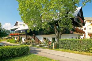 un gran edificio blanco con un árbol delante en House Klasika - Adults Only en Bled