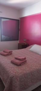 a bedroom with a bed with three towels on it at Confortable Apartamento en Microcentro in Barraquero