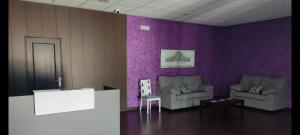 a living room with two chairs and purple walls at Las Talliscas in Casas de Don Gómez +14 photos