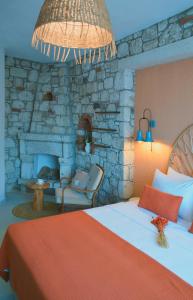 a bedroom with a bed and a stone fireplace at Rijeka Alaçatı in Çeşme