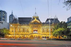 ein großes gelbes Gebäude mit einer Straße davor in der Unterkunft City Haven with Breathtaking Views in Melbourne