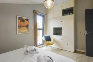 sypialnia z łóżkiem i żółtym krzesłem w obiekcie Superbe villa 5* avec piscine chauffée w mieście Labenne +37 zdjęć