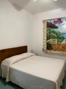 Seaview apartments في فوروري: غرفة نوم بسرير ودهان على الحائط