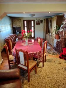 a dining room with a table with a vase of flowers on it at Casa Tudor-Nicolae in Borşa