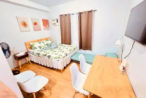 a room with a bed and a table and chairs at Mesatierra Garden Residences in Davao City +8 photos